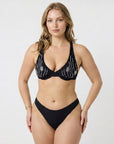 Woman wearing a sustainable black bikini with glass beading shot in a studio