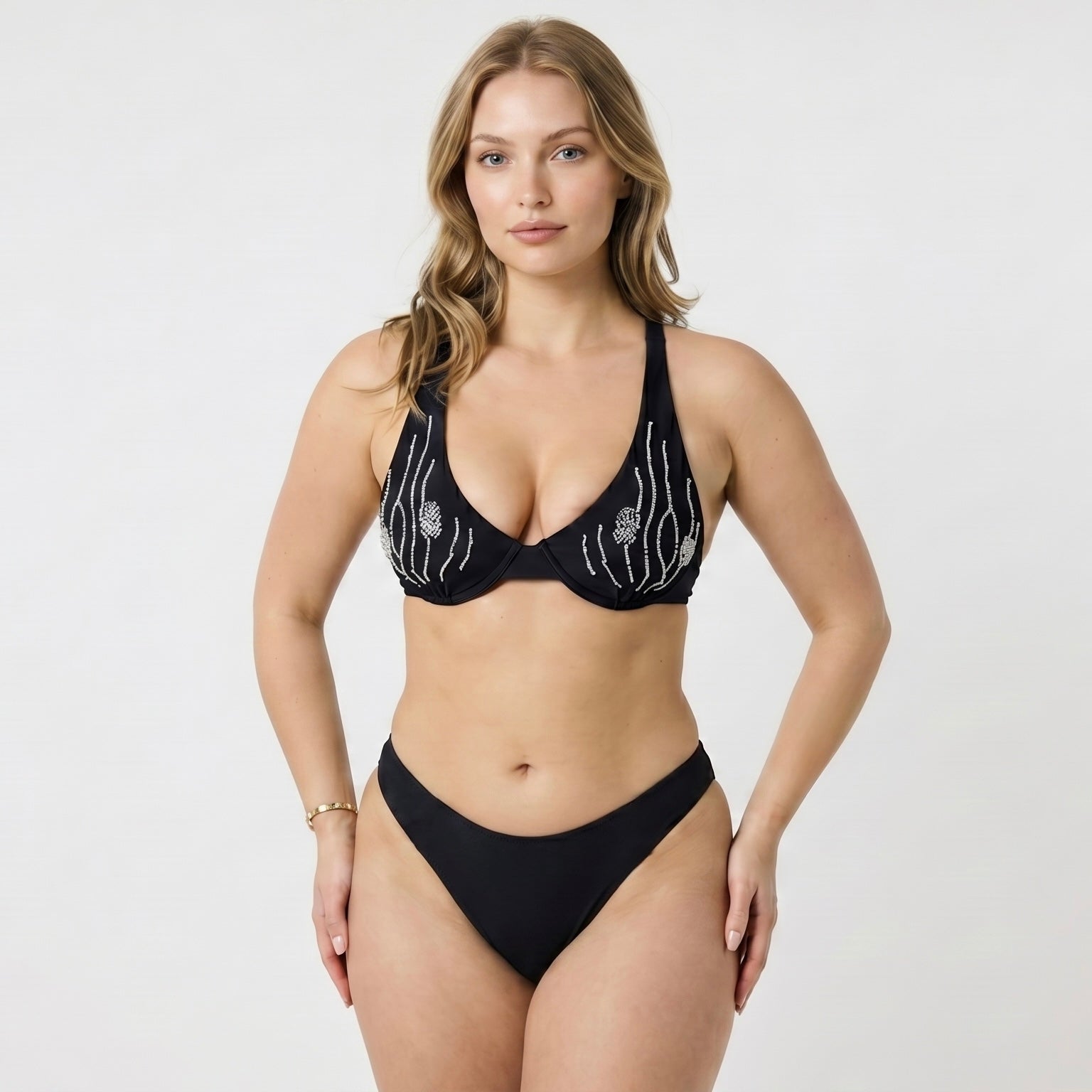 Woman wearing a sustainable black bikini with glass beading shot in a studio