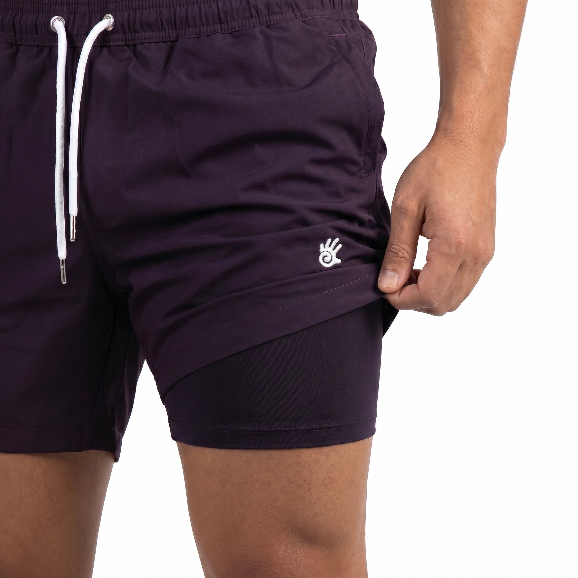 Model stands straight on and is holding the swim shorts up to show the built in boxer lining showing the anti-chafe swim shorts benefits.