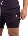 Model stands straight on and is holding the swim shorts up to show the built in boxer lining showing the anti-chafe swim shorts benefits.