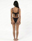 women wearing a sustainable black bikini with a bow detail on a white background